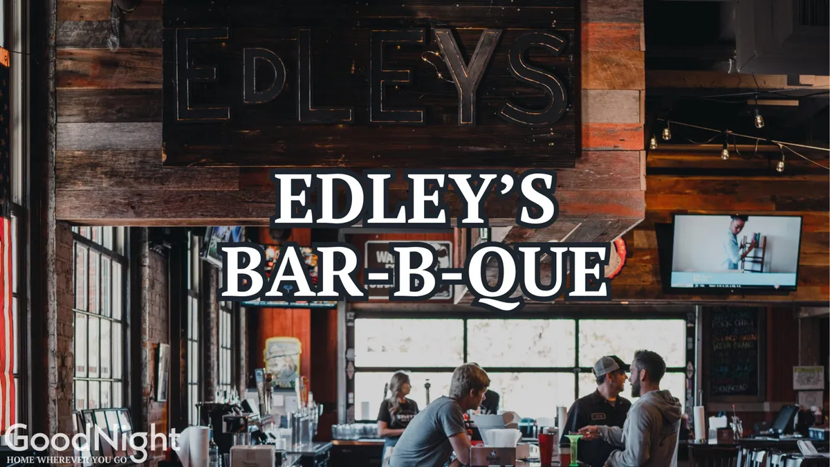 An interior view of Edley’s Bar-B-Que, featuring its lively bar counter, prominent signage, and patrons enjoying meals together. The energetic atmosphere is complemented by communal dining and the presence of families and friends.